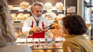 Panadero en el mostrador iluminado de su tienda